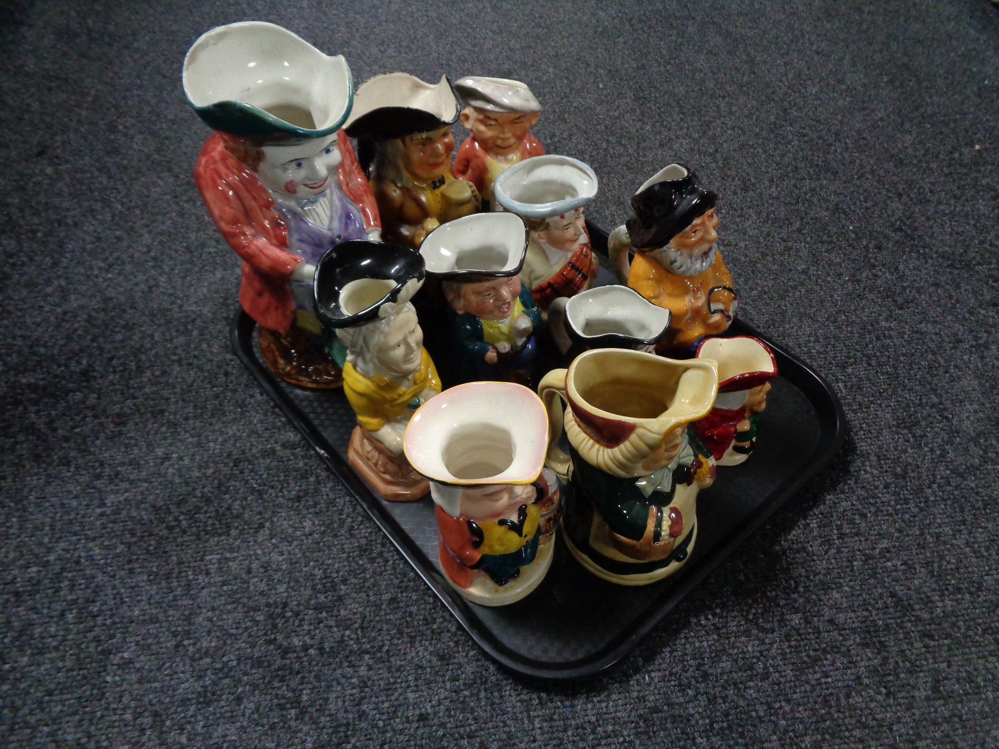 A tray of eleven antique and later character jugs