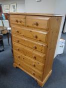 A contemporary pine seven drawer chest