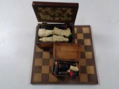 A wooden chess board together with two boxes containing chess pieces.