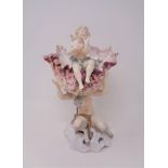 A 19th century continental china comport modelled as a fawn holding aloft a shell with a cherub