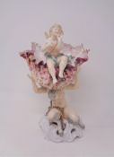 A 19th century continental china comport modelled as a fawn holding aloft a shell with a cherub