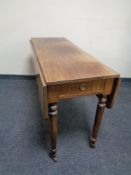 A nineteenth century mahogany Pembroke table fitted a drawer on reeded legs