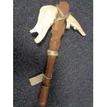 A rustic tribal hand axe with animal jaw blade