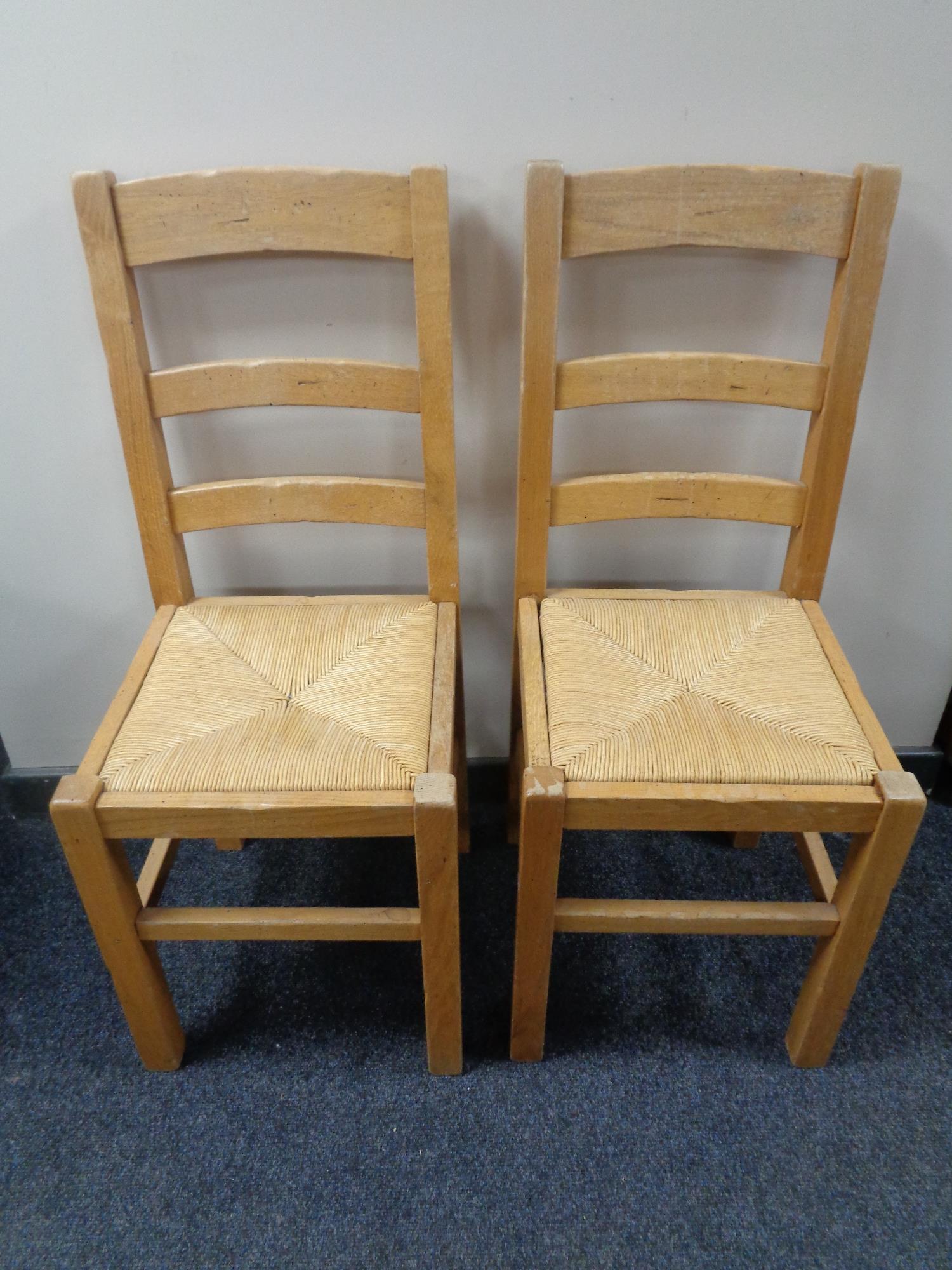 A pair of pine ladder backed rush seated chairs