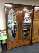 An Edwardian inlaid mahogany double mirror door wardrobe fitted with a drawer