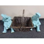 A wicker hand basket together with two elephant figures.