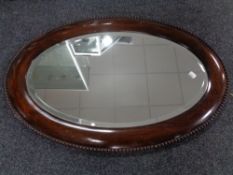 A 19th century oval beaded framed bevelled edge mirror