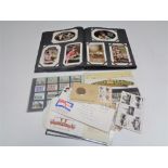 An early 20th century postcard album of greetings cards and small quantity of stamps,