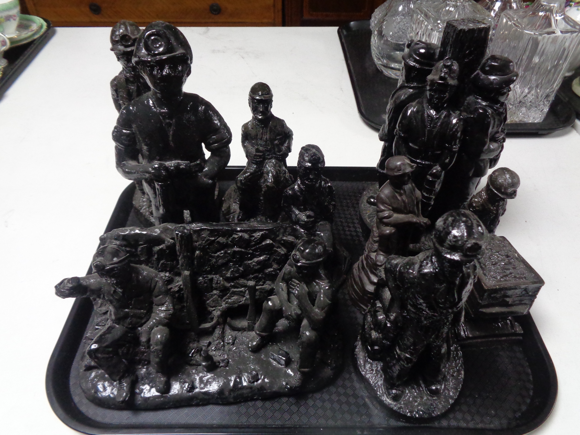 A tray containing coal figures, miners.