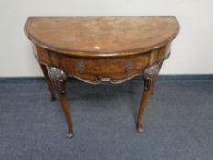 A nineteenth century figured walnut demi lune table on Queen Anne style legs