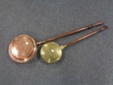 Two bed warming pans, one brass, one copper.