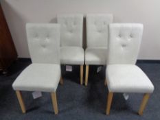 A set of four contemporary buttoned back dining chairs upholstered in beige fabric