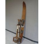 A vintage Gilcraft water ski together with a canvas golf bag containing seven assorted driver's and