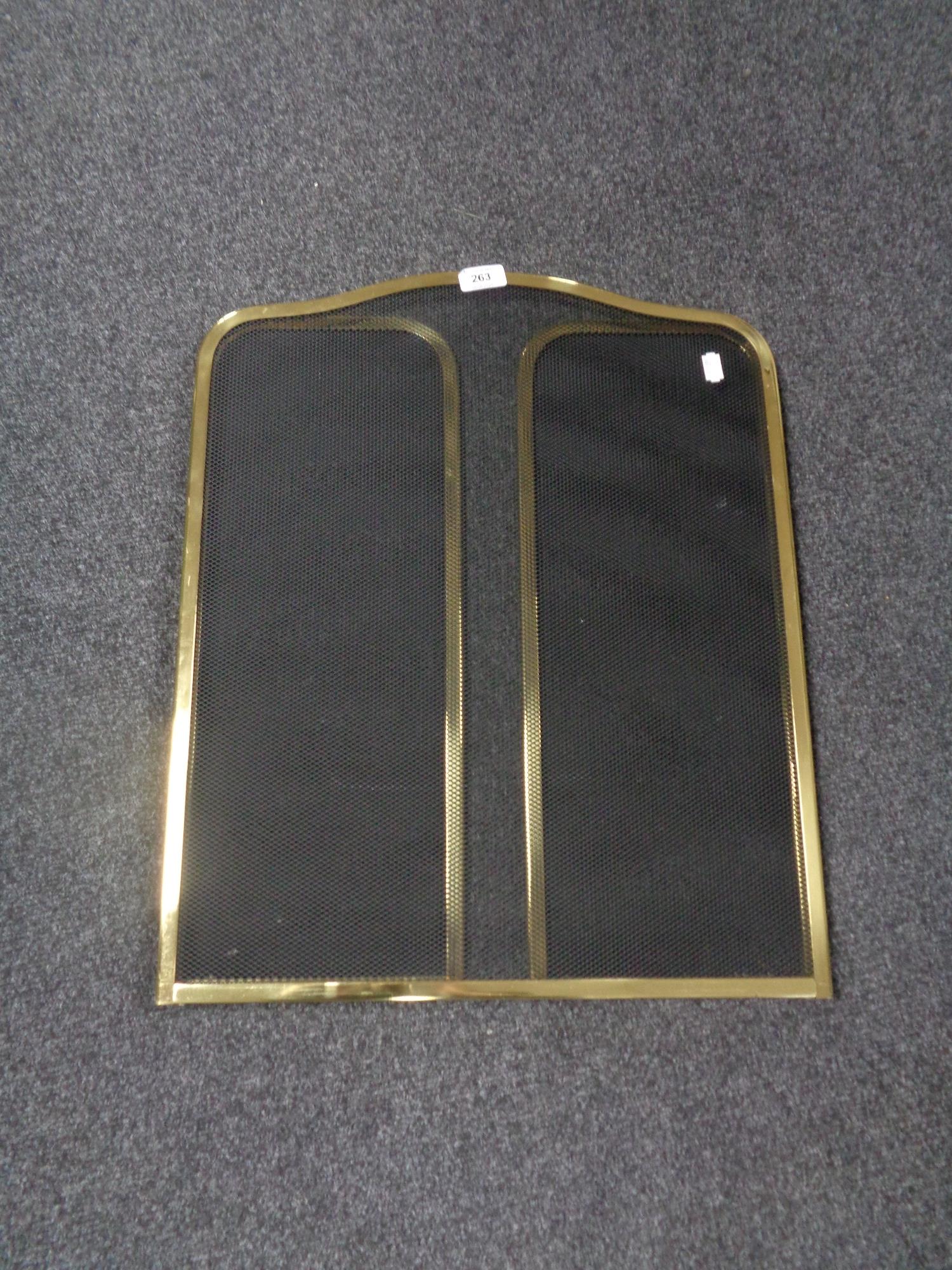 A brass three way folding spark guard.