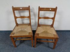 A pair of Continental inlaid oak antique dining chairs with rush seats