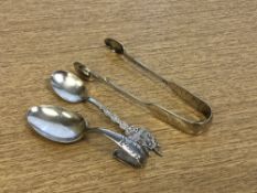 A silver caddy spoon, together with silver sugar tongs and a continental silver crested spoon.