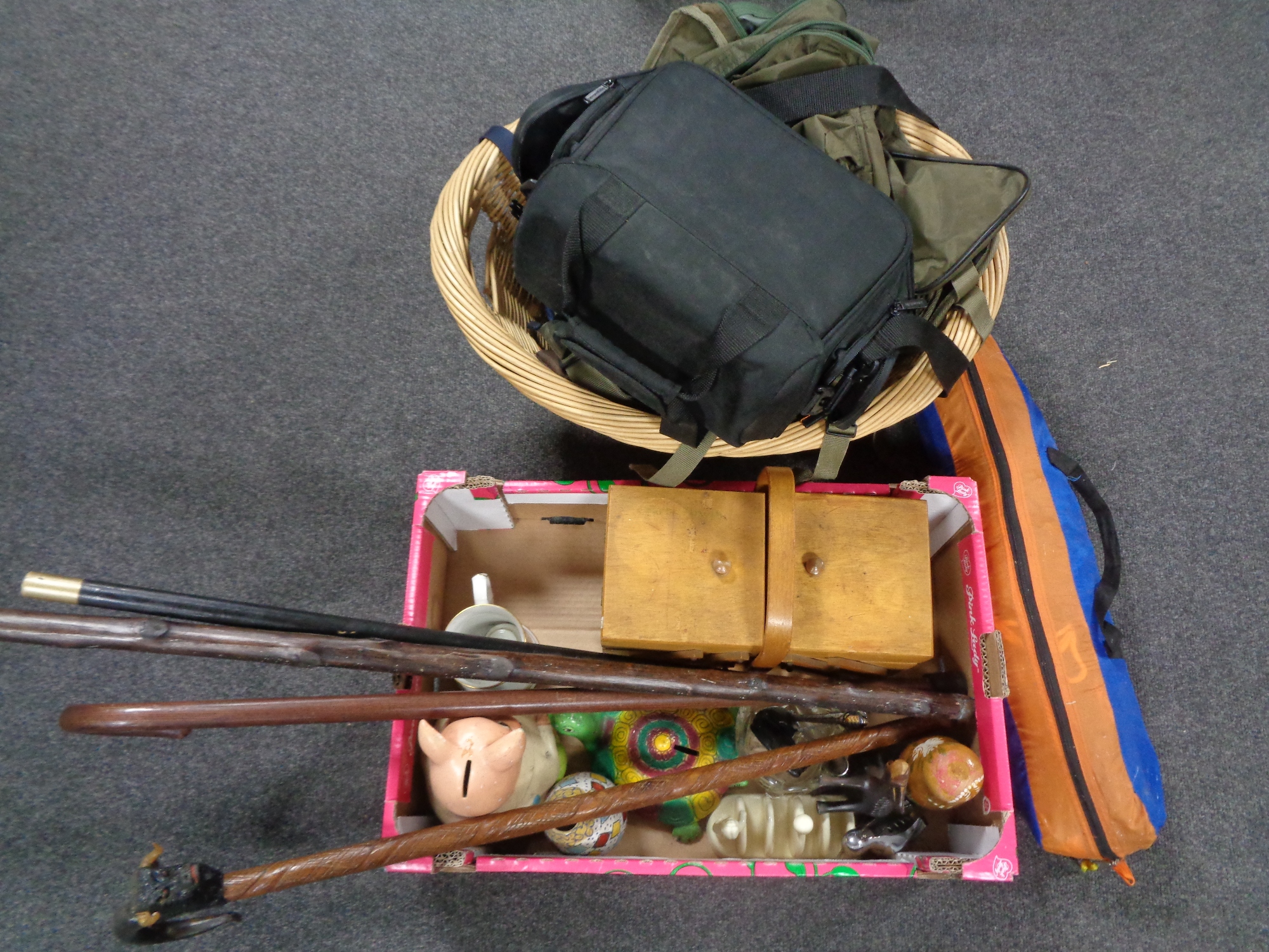 A wicker basket containing holdalls together with a tent in carry bag and a box containing waking