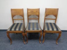 A set of seven twentieth century Continental oak dining chairs together with one other similar