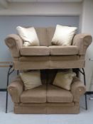 A pair of two seater settees in brown fabric with cream cushions