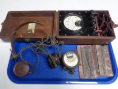 A cased Bakelite voltmeter together with a Pifco voltmeter, set of vintage headphones.