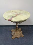 A circular faux onyx topped bar table on cast iron base,