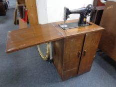 A mid century Singer sewing machine in cabinet