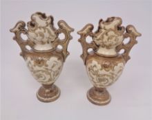 A pair of miniature continental pottery twin handled vases,