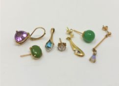 A group of gold single earrings and a pendant, set with amethyst, jade,