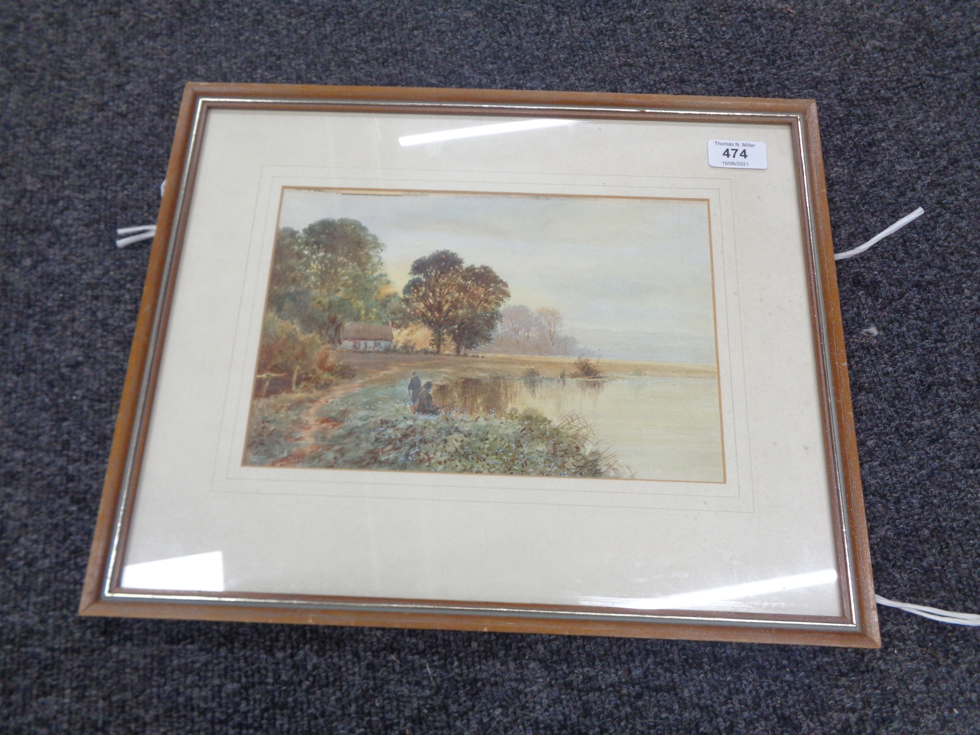 An early 20th century John W Hepple watercolour, figures fishing by a lake with dwelling beyond.