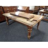 A Victorian mahogany wind out dining table with handle and two leaves.