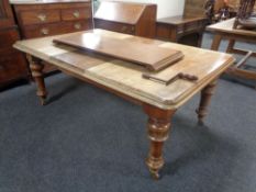 A Victorian mahogany wind out dining table with handle and two leaves.