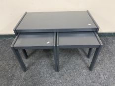 A nest of three 20th century painted teak tables
