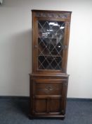 A good quality carved oak corner display cabinet with leaded glass door,