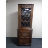 A good quality carved oak corner display cabinet with leaded glass door,