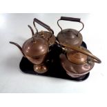 Three antique copper kettles together with a copper teapot.