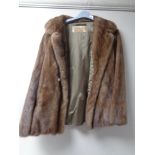 A mink fur coat together with a mink fur brooch.