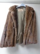 A mink fur coat together with a mink fur brooch.