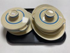 A tray of five pieces of Clarice Cliff Newport pottery dinner ware to include two lidded tureens,