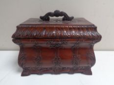 A carved Eastern table box with lift out tray in a mahogany finish.