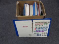 A box containing folders and albums of stamps of the world.