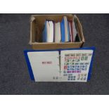 A box containing folders and albums of stamps of the world.