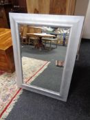 A contemporary silvered framed bevelled mirror