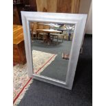 A contemporary silvered framed bevelled mirror