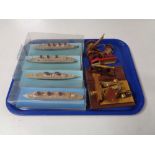 A tray containing miniature wooden cannons and four miniature models of cruise liners in display