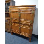 A Chinese style elm cabinet with bamboo panel doors.