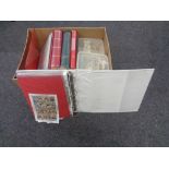 A box containing folders and albums of stamps of the world,