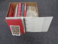 A box containing folders and albums of stamps of the world,