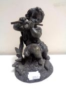 An antique Spelter figure, seated cherub with flute.