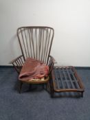 An Ercol elm and beech wingback armchair with stool (no cushions,