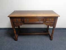 A good quality carved oak refectory hall table, fitted three drawers.